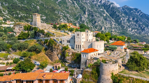 Aerial drone view of Kruje Castle and its fortress, inside the Kruje tower and museum with the mountains in the background. Albania