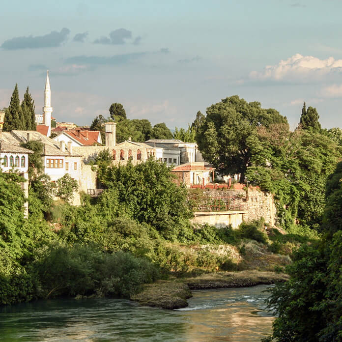 Panorama of the old town of Mostar, Bosnia and Herzegovina, with a focus on Neretva river and ottoman buildings and Mosque Minarets. Mostar is the biggest city of Herzegovina