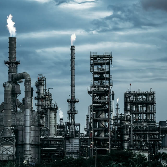 Oil Refinery Plant with Fuel Storage Tanks and Complex Piping System, Captured Under Clear Blue Sky for Industrial Energy and Petrochemical Concept