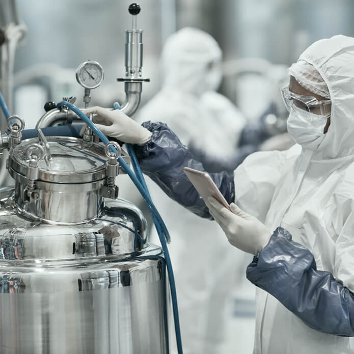 Portrait of female worker wearing protective suit while operating equipment at modern chemical plant, copy space