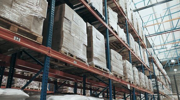 Boxes, warehouse and logistics parcel in supply chain, stock and commercial factory with shelves for ecommerce. Wholesale, delivery and shipping or distribution, cargo and empty depot storage