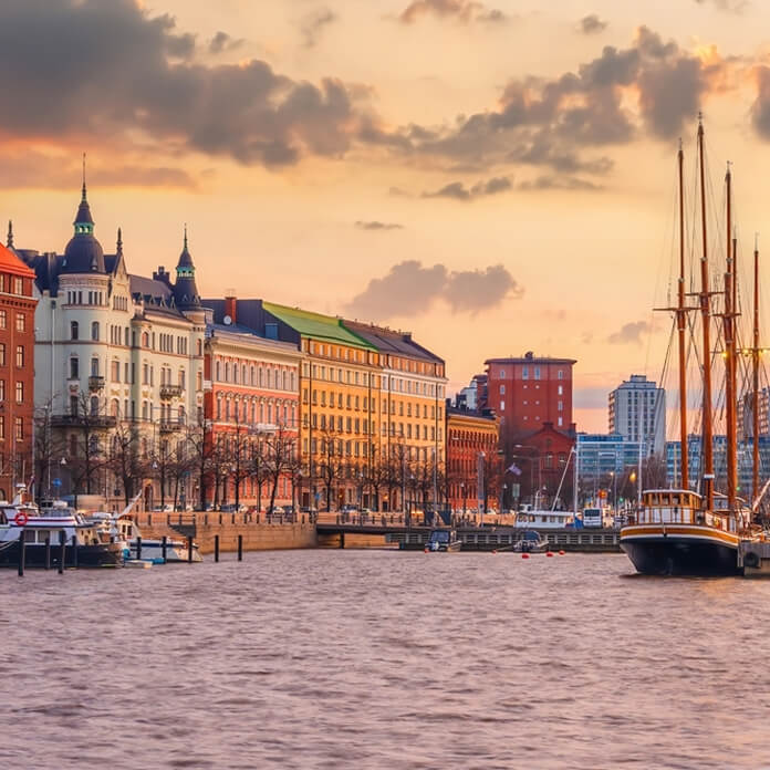Helsinki city skyline, cityscape of Finland at sunset. Boat in a view.