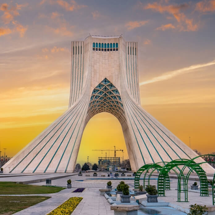 At sunset, locals enjoy a leisurely evening at this iconic landmark in Tehran, the capital of Iran. Azadi Towers, Iran.