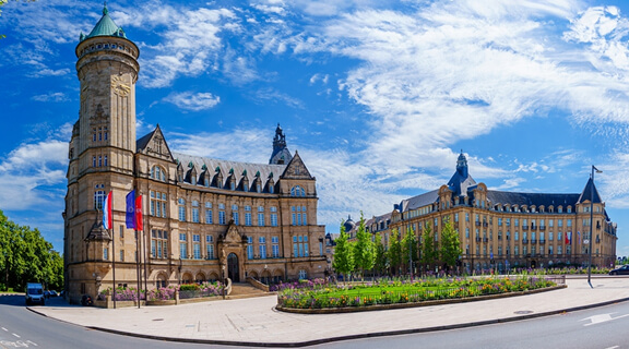 A stunning cityscape of Place d Armes Square in Luxembourg, showcasing its historic buildings, vibrant atmosphere, and blue skies, inviting visitors to explore the charm of Luxembourg City.
