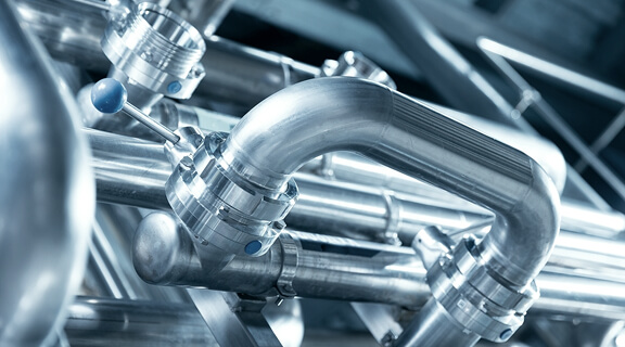 Stainless steel pipes and valves in modern beer brewery facility.