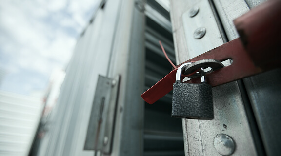 Close-up of closed cargo container on lock, sealed container in warehouse area
